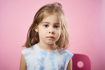 Naklejka premium isolated cute little girl in a dress posing on a pink background