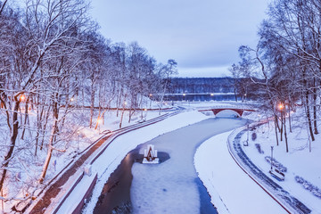 City park in the snow winter evening