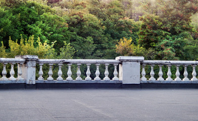 scene with white marble parapet and green forest