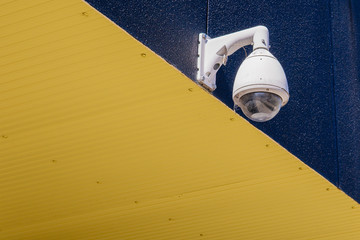 A modern CCTV security camera under the eaves.