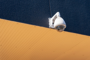 A modern CCTV security camera under the eaves.