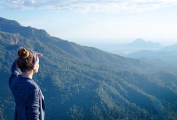 Fototapeta na wymiar A woman looking afar atop a mountain