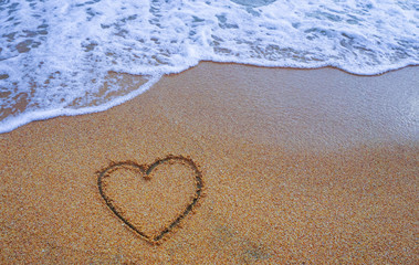 Heart on sand beach with white wave,symbol of love,beautiful sea background,handwritten,valentine