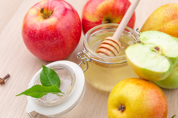 Jewish holiday Rosh Hashanah background with honey and apples on wooden table.