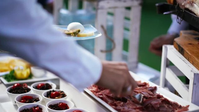 The waiter serves buffet catering food set on table iin hotel or luxury restaurant in the event party outdoor. 4K UHD.