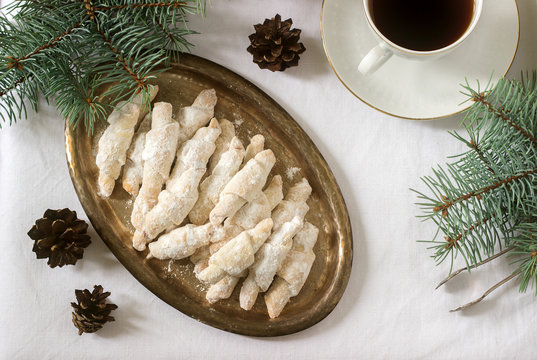 Traditional Romanian or Moldovan shortcake cookies with jam stuffing and a cup of tea on the background of winter decor.
