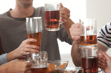 Group of cheerful friends drinking beer in bar