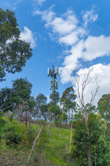 Mobile phone communication repeater antenna. Cell tower against blue sky background in Melbourne, Australia.