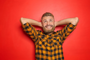 Portrait of handsome man with dyed hair and beard on color background