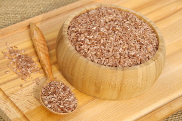 Uzbek devzira rice in bamboo bowl and wooden spoon