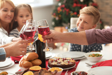 Happy family clinking glasses during Christmas dinner at home