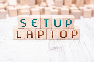 The Words Setup Laptop Formed By Wooden Blocks On A White Table