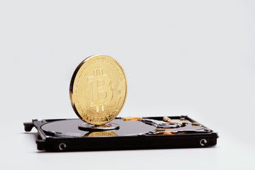Closeup of a gold bitcoin on the hard disk drive.