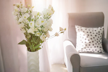 Vase with beautiful flowers near window indoors