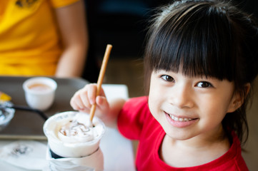 Close Up image of cute little girl drink milkshake in restaurant.