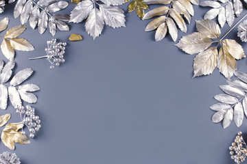 Winter concept flat lay with golden and silver leaves. Christmas frame background