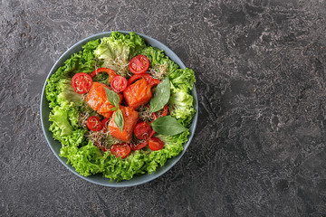 Healthy fresh salad with salmon on grunge background