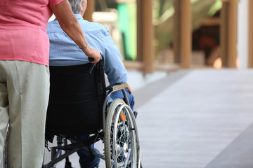 Senior man in wheelchair and his wife on ramp outdoors