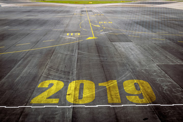 Closeup 2019 figures on the surface of the airport runway texture background.