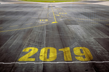 Fototapeta na wymiar Closeup 2019 figures on the surface of the airport runway texture background.