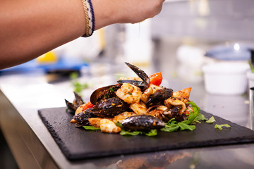 Fine cuisine with seafood on black stone in restaurant kitchen.Delicious food