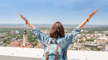 Happy young woman tourist traveler looking at the city view of Leipzig from a bird's eye view from...