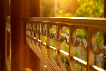 Fragment of the fence with metal columns in the rays of the sunset. Veranda restaurant