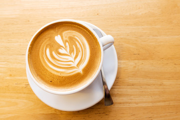 Hot coffee latte on a wooden table.
