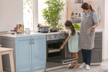 Mother and daughter cooking together in kitchen