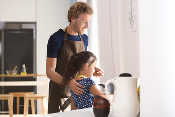 Father and daughter cooking together in kitchen