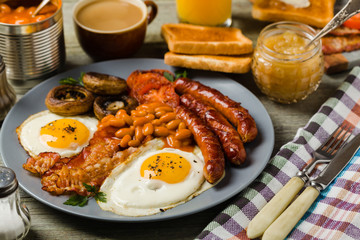 Full English breakfast, with sausage, mushrooms, beans and a fried egg.