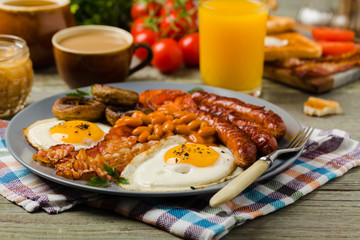 Full English breakfast, with sausage, mushrooms, beans and a fried egg.