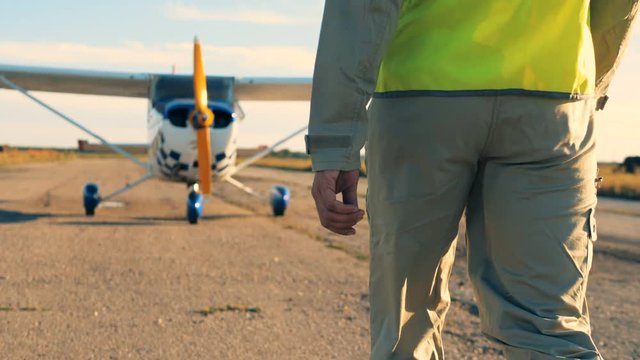 Pilot going on a runway, back view. Professional pilot coming to his plane, walking on an airfield.