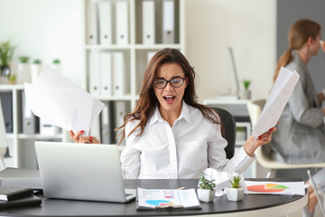 Stressed businesswoman at table in office