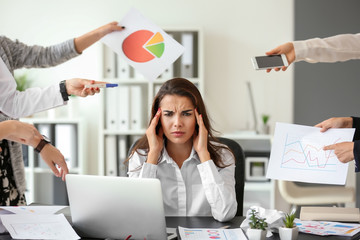 Stressed worker with a lot of work sitting at table in office