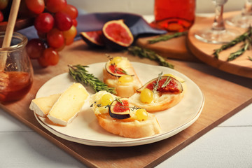 Tasty sandwiches with cheese, grape and fig on plate