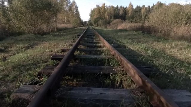 The camera is moving over the old coutryside railway tracks, wide angle perspective point of view