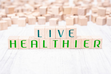 The Words Live Healthier Formed By Wooden Blocks On A White Table