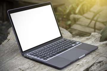 Blank screen laptop computer on wooden table.