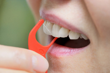 Woman cleaning her teeth with an orthodontic flosser