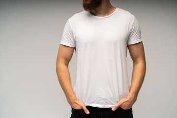 Young man wearing blank white t-shirt isolated on white background. Copy space. Place for...