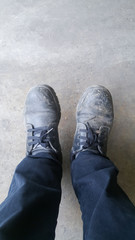Man with black shoe on cement floor, safety shoes on industrial worker