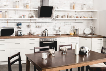 interior of modern white kitchen with table ready for breakfast