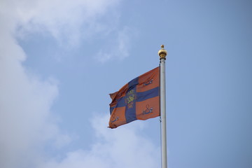 Flag of king Willem-Alexander is waving in the wind on the Noordeinde Palace in the hague, The Netherlands. The flag is symbolizing that the king is in the palace.