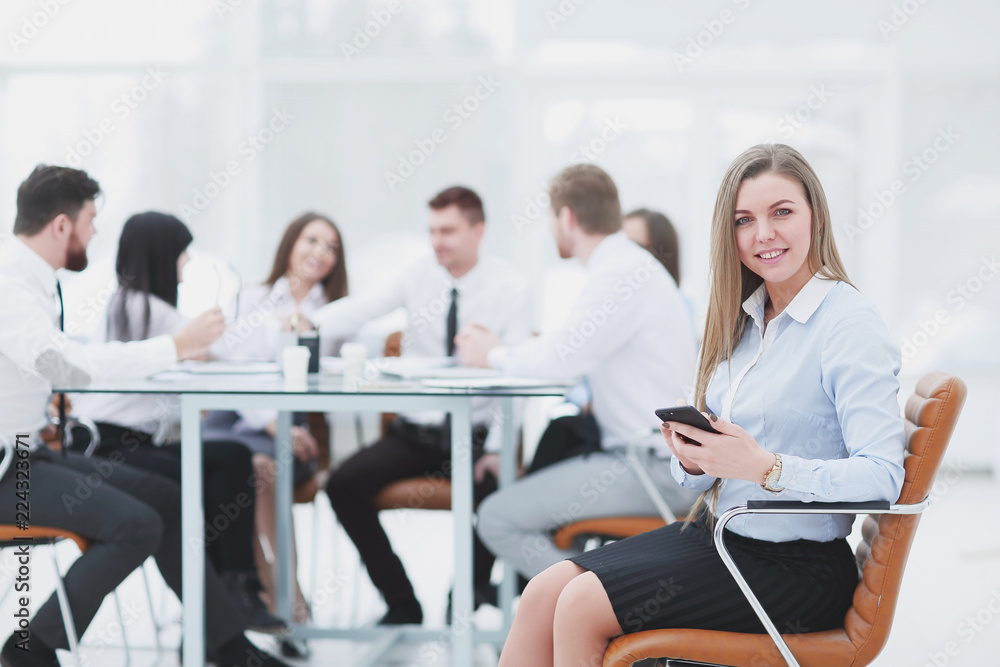 Wall mural young employee with a smartphone on the background of business team