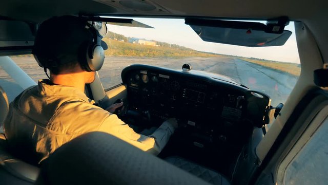 Pilot navigates a biplane on an airfield. Cockpit view.