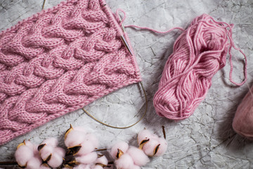 Pink knitting wool and knitting needles on white background
