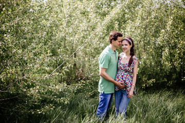 Pregnant couple girl holding her tummy.