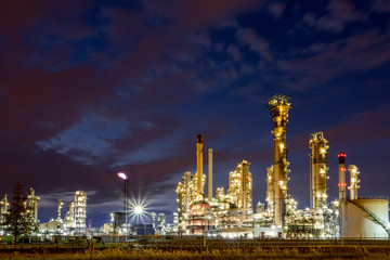 Glittering industrial lights of an oil and gas refinery or petrochemical plant with a blue purple sky background at night