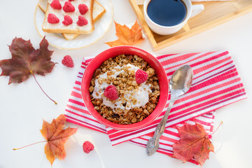 still life: granola with raspberries, toast with curd cheese and raspberries, coffee and autumn leaves